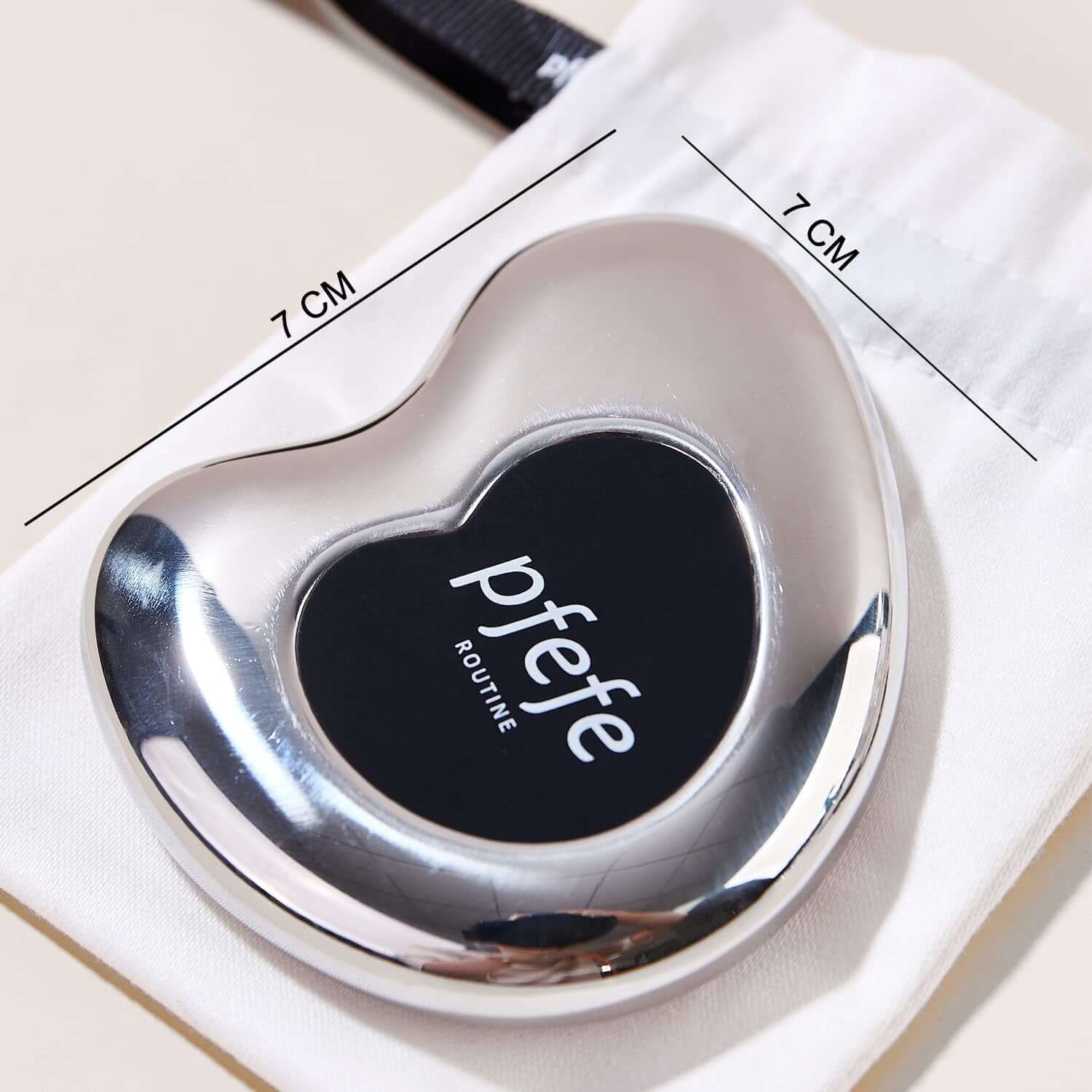 Stainless steel Pfefe cryo gua sha tool in a heart shape, measuring 7 cm, for facial and body skincare.