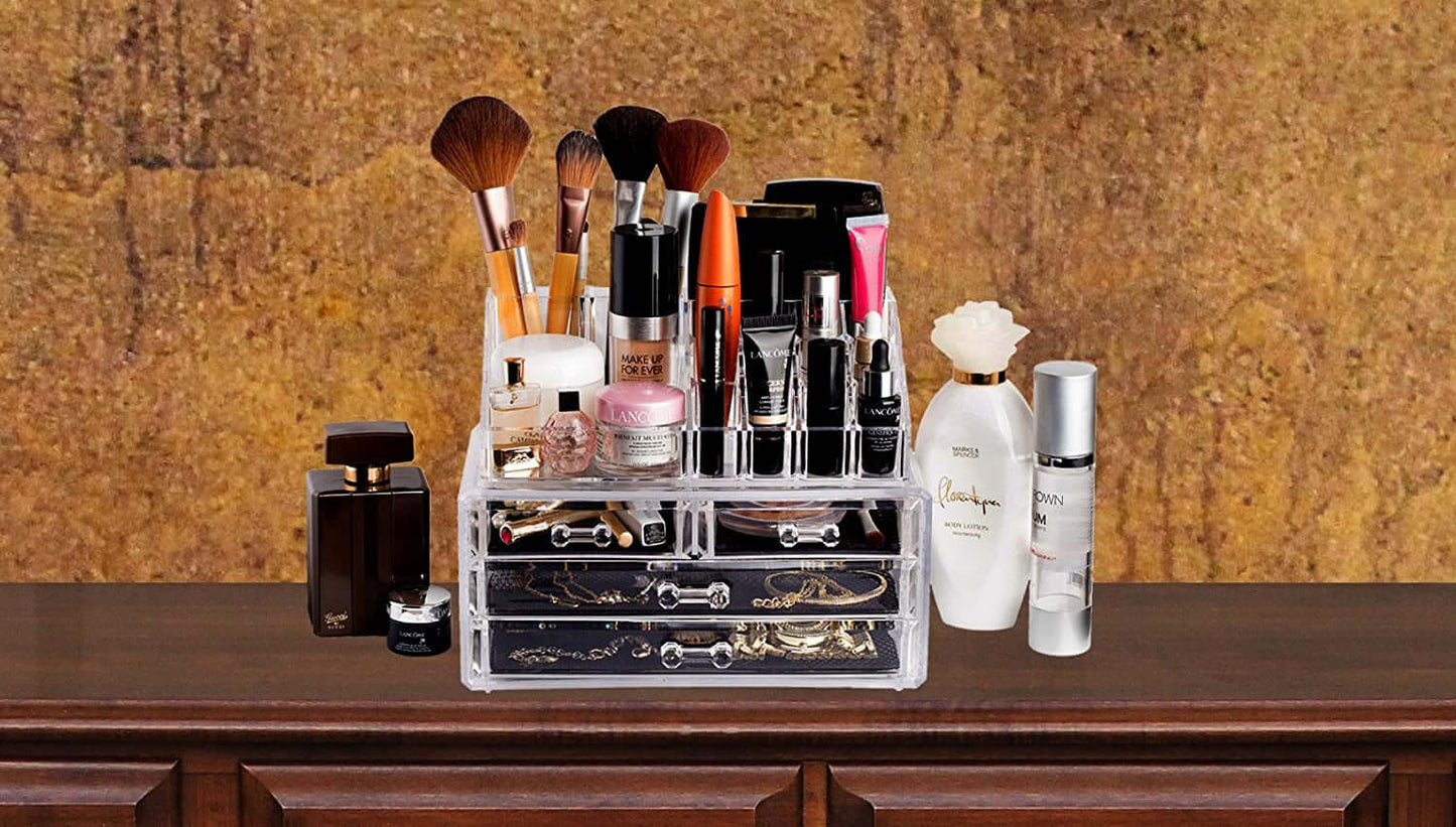 Clear makeup organizer with compartments holding brushes, lipsticks, and skincare products on a wooden vanity.