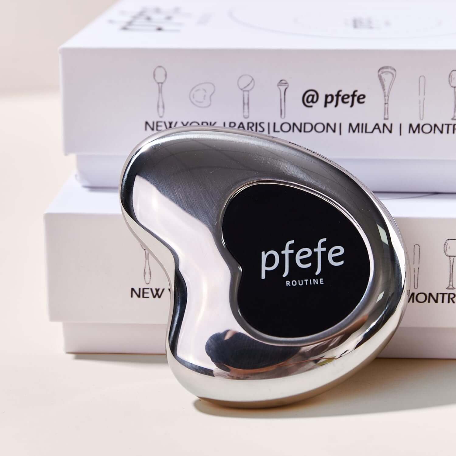 Stainless steel Pfefe cryo gua sha tool on display with packaging for facial and body care.